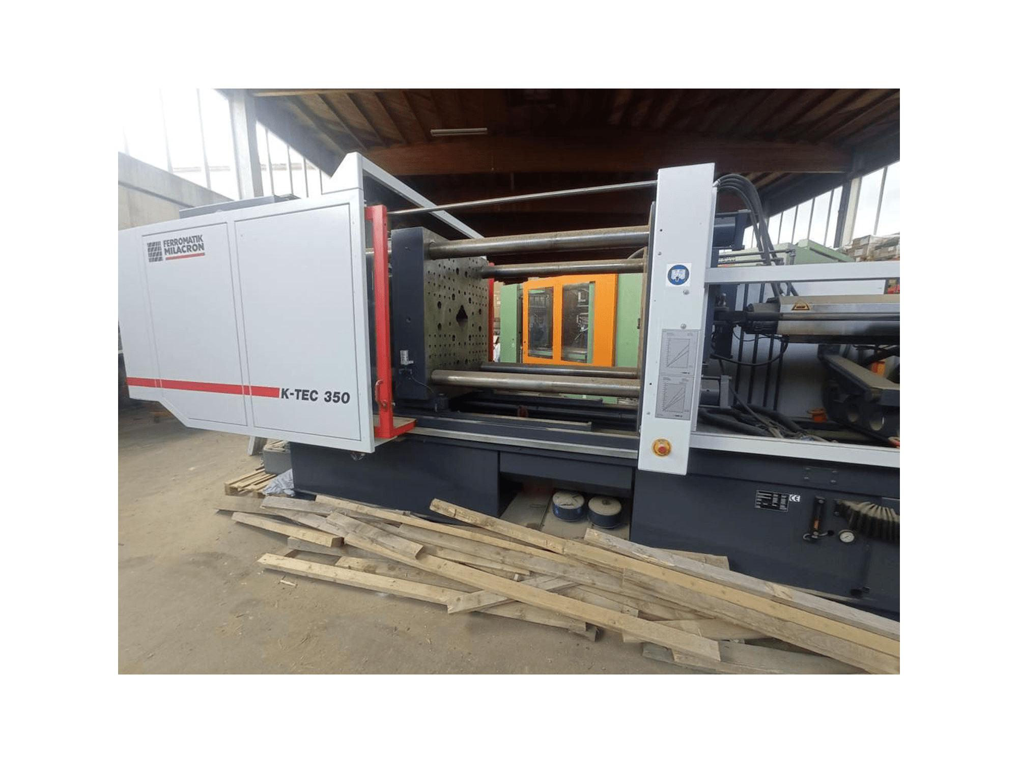 K-TEC 350 från Ferromatik Milacron, sedd från sidan, visar upp det komplexa maskineriet och de operativa kontrollerna.