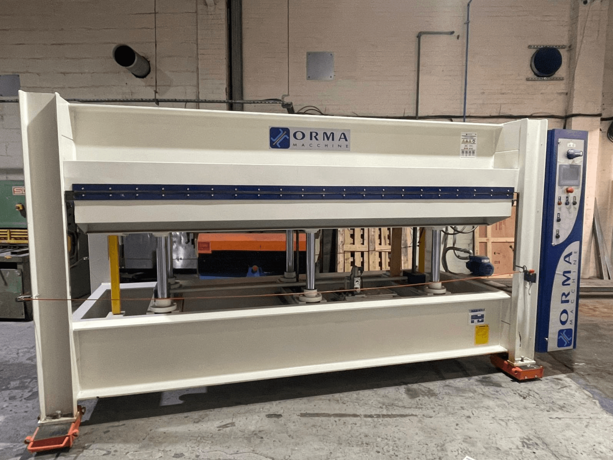 Orma Macchine hydraulisk press framifrån, med fyra vertikala stöd och kontrollpanel på höger sida.